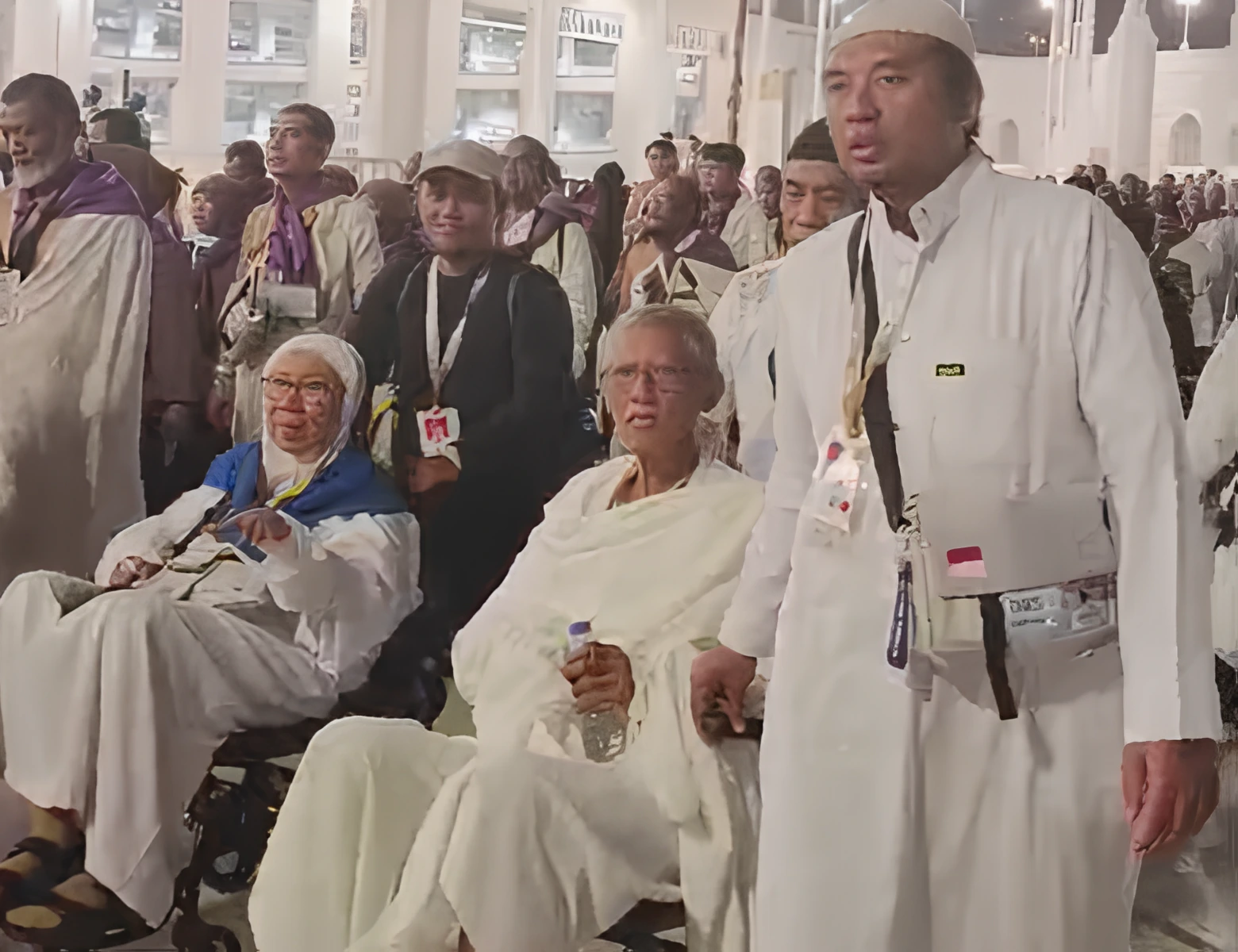 Jemaah lansia KBIHU Muhammadiyah Semarang duduk khusyuk di kursi roda dikawal relawan jemaah saat umrah wajib di pelataran Masjidil Haram Makkah.