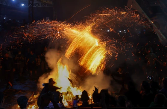 Sabetan obor daun kelapa yang menghasilkan percikan bunga api dramatis di tengah kegelapan malam saat warga menggelar tradisi Perang Obor Jepara di Desa Tegalsambi.