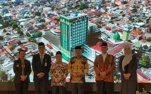 Enam tokoh berpose sejajar di depan layar LED besar visualisasi gedung baru RS Roemani Semarang yang tinggi dan modern berwarna hijau-kaca di tengah pemukiman padat, berdekatan dengan masjid kubah hijau. Wali Kota Semarang, Dr. Haedar Nasir, Dr. Tafsir, dan dr. Sri Mulyani terlihat jelas di barisan depan.