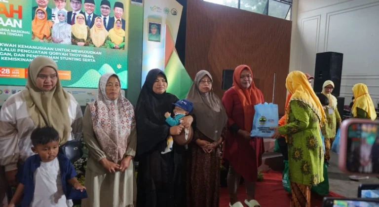 Penyerahan simbolis bantuan tas biru kepada perwakilan ibu dan anak oleh petugas berseragam hijau dalam acara Jambore Dakwah Kemanusiaan Aisyiyah Jateng di Wonderpark Tawangmangu untuk program cegah stunting.