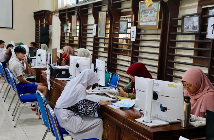 Calon siswa menyerahkan dokumen kepada petugas panitia di loket sekolah saat proses verifikasi berkas daftar ulang SMA Jateng 2026.