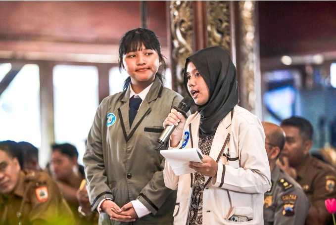 Dua siswi perwakilan Forum Anak Kota Tegal Bahari memegang mikrofon menyuarakan keresahan terkait dampak psikologis perundungan di hadapan pejabat Pemprov Jateng.