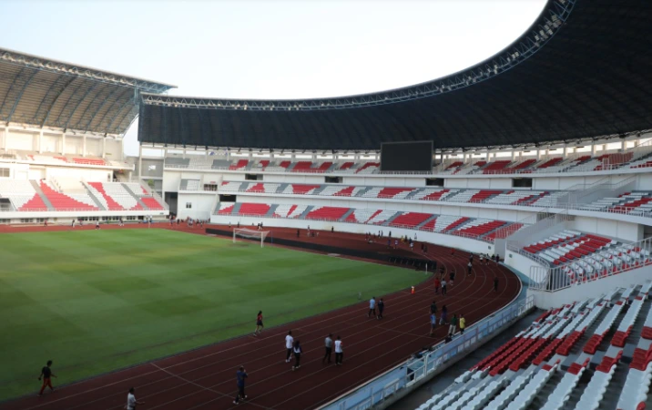 Suasana masyarakat umum sedang berolahraga lari mengelilingi lapangan memadatkan jadwal lari Stadion Jatidiri Semarang di lintasan atletik pada pagi hari.