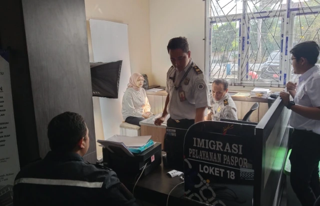 Petugas Imigrasi Semarang sedang memproses foto biometrik pemohon wanita di loket Mal Pelayanan Publik saat layanan kuota paspor Demak 2026 ludes diserbu warga.