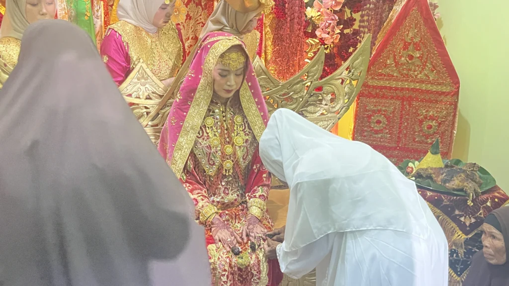 Calon pengantin wanita Inthan Noer Afrida menjalani prosesi sakral pemasangan inai pada tradisi Malam Bainai adat Minang di Pesawaran Lampung.
