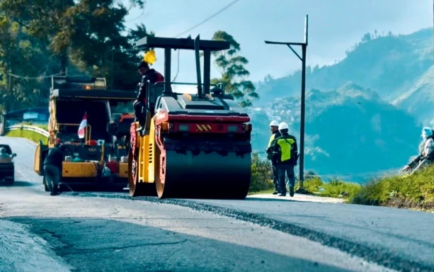 Alat berat sedang mengaspal ulang jalur pegunungan sebagai ilustrasi proyek jalan rusak Jateng diperbaiki total pada 2026.