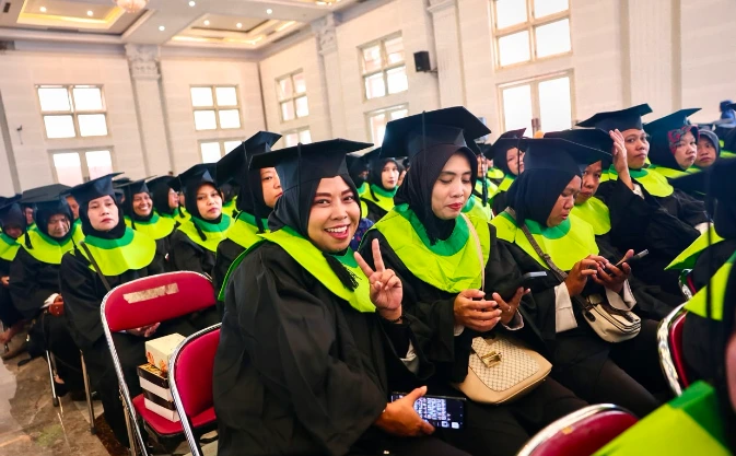 Ribuan ibu-ibu warga Klaten tersenyum bangga mengenakan toga hitam berkerah hijau saat mengikuti wisuda graduasi mandiri PKH sebagai simbol warga tolak bansos dan keberhasilan mandiri secara ekonomi.
