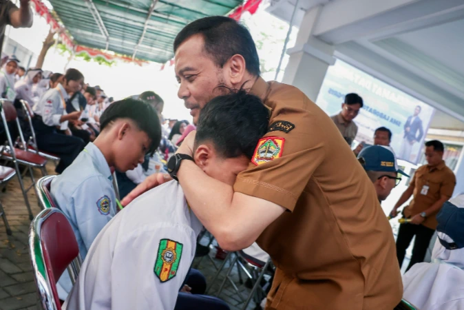 Gubernur Jawa Tengah Ahmad Luthfi memeluk erat seorang siswa berseragam SMA untuk memberikan semangat dalam acara program Sekolah Gratis Jateng di SMA Laboratorium UPGRIS Semarang.