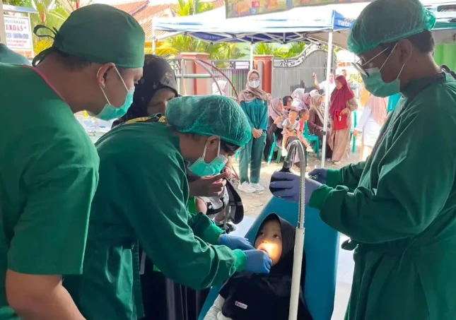 Dokter spesialis dari RSGMP Unsoed melakukan pemeriksaan gigi anak dalam layanan kesehatan gratis Unsoed melalui Program SPELLING di Kedungbanteng, Banyumas.