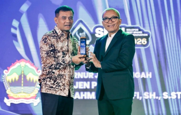 Gubernur Jawa Tengah Ahmad Luthfi mengenakan kemeja batik menerima trofi penghargaan Impactful Regional Leadership dari CEO Solopos Media Group pada ajang SBBI Award 2026 atas prestasinya memajukan ekonomi Jawa Tengah.