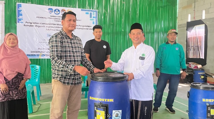 Ketua Tim Pengabdian Masyarakat Polimarin menyerahkan tong komposter biru kepada tokoh masyarakat RW 3 Genuk Ungaran untuk dukung program pengolahan sampah rumah tangga mandiri.