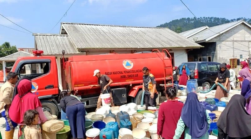 Pemandangan kerumunan warga di Jawa Tengah mengantre membawa berbagai ember dan jeriken untuk menerima distribusi air bersih dari truk tangki merah bertuliskan Badan Nasional Penanggulangan Bencana (BNPB)
