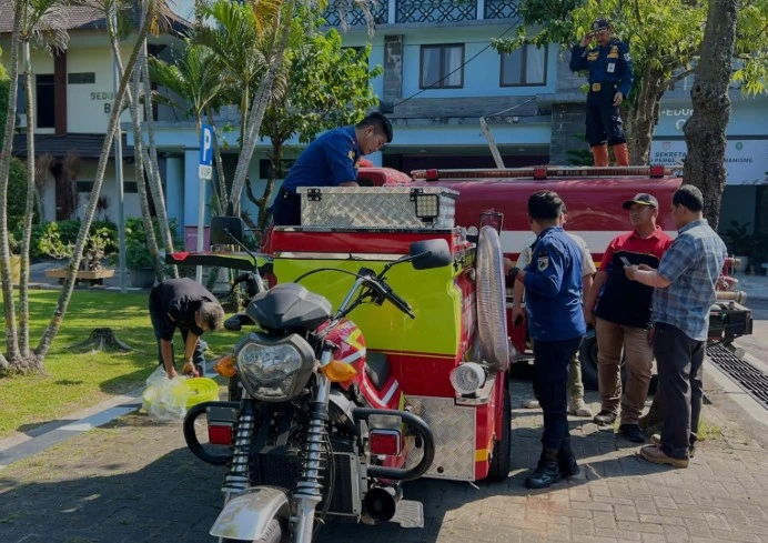 Motor damkar roda tiga berwarna merah milik Pemadam Kebakaran Demak yang bersiaga sebagai solusi kebakaran gang sempit di area permukiman padat penduduk.