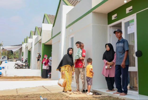 Sejumlah warga penerima manfaat berdiri di depan deretan rumah KPR subsidi di Perumahan Puri Delta City Side Batang, wujud nyata percepatan penanganan backlog rumah Jateng.