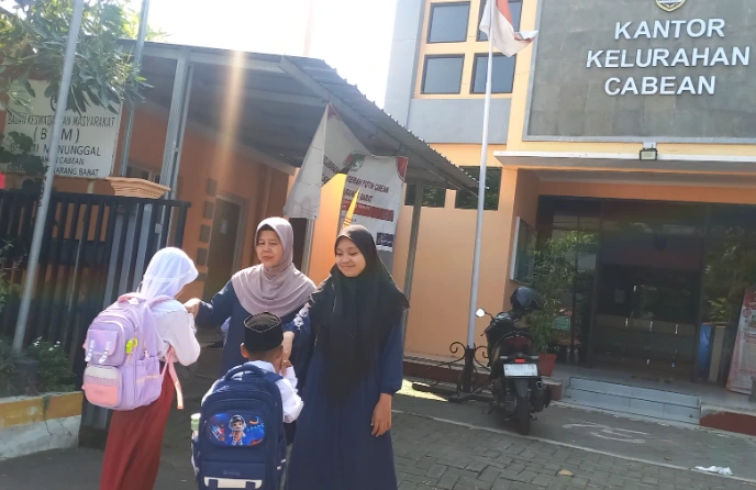 Siswa SD Muhammadiyah 07 Semarang bersalaman dengan guru di depan Kantor Kelurahan Cabean yang dialihfungsikan sebagai ruang kelas darurat.