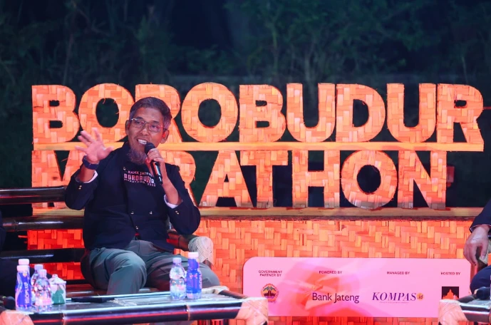 Sekda Provinsi Jawa Tengah Sumarno memegang mikrofon dan memberikan penjelasan berlatar ornamen anyaman bambu bertuliskan Borobudur Marathon, terkait informasi pendaftaran Borobudur Marathon 2026.