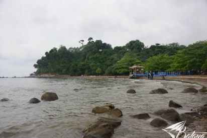 Lanskap bebatuan di pesisir Pantai Ujungnegoro Kabupaten Batang dengan latar pepohonan hijau, lokasi beroperasinya wahana speedboat viral.