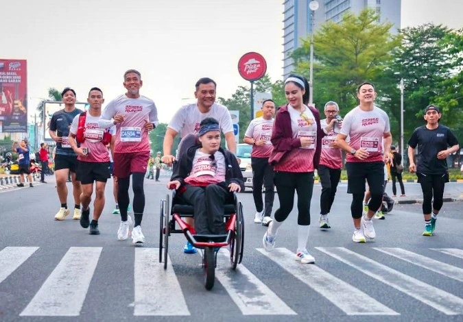 Gubernur Jawa Tengah Ahmad Luthfi tersenyum sambil mendorong kursi roda putranya, Mohammad Alif Daffa, di tengah ribuan pelari ajang Sukoharjo Spektakuler Run 2026.
