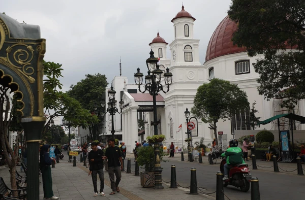 Suasana keramaian wisatawan nusantara memadati kawasan cagar budaya Kota Lama Semarang dengan latar belakang ikon Gereja Blenduk pada sore hari.