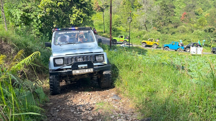 Armada Jeep Adventure menaklukkan rute offroad berbatu melintasi ladang sayur dalam paket wisata Jeep Tawangmangu, Karanganyar.
