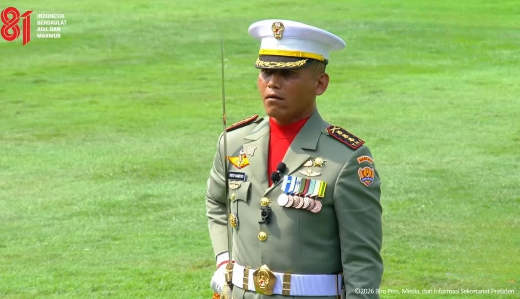 Potret Dandim Semarang Priyo Handoyo berdiri tegap mengenakan seragam kebesaran militer sambil menghunus pedang komando saat memimpin Upacara HUT ke-81 RI di lapangan Istana Merdeka.