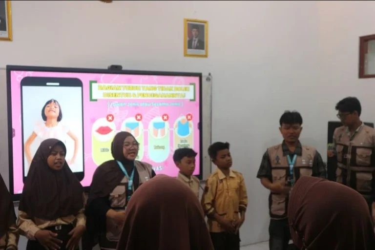 Mahasiswa KKN UIN Walisongo memandu siswa pramuka SDN Podosoko 1 Magelang di depan layar interaktif yang menampilkan batas larangan sentuhan tubuh, sebagai bagian dari edukasi seksual anak dan perlindungan anak usia dini.