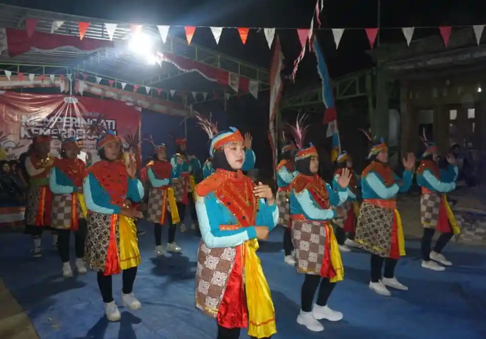 Mahasiswa KKN UIN Walisongo dan warga menampilkan kesenian tari tradisional Kubro Jiwo Mudo dengan kostum cerah bernuansa biru, merah, dan topi berbulu di bawah tenda malam tirakatan kemerdekaan di Dusun Garon Magelang