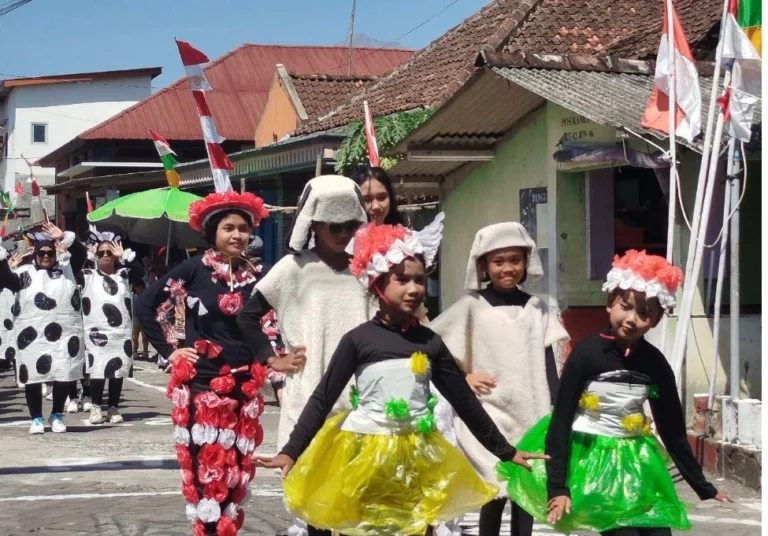 Sekelompok anak dan remaja berdiri tegap memperagakan kostum daur ulang karnaval dari limbah plastik berwarna-warni di jalanan desa saat memeriahkan Kirab Budaya Semarang.