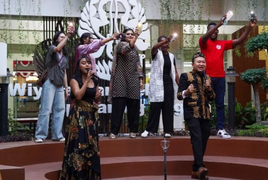 Mahasiswa asing nyanyi dangdut dan lagu pop Indonesia sambil menyalakan senter ponsel di atas panggung lomba 17 Agustus Undip.
