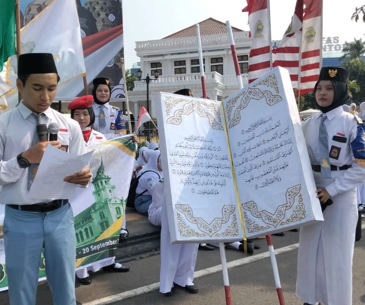 Siswa SMK Muhammadiyah 1 Semarang membawa replika Al-Qur'an raksasa dan membacakan deklarasi dukungan MTQ Nasional 2026 saat pawai unik HUT RI di Wisma Perdamaian.