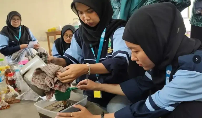 Dua mahasiswi KKN UIN Walisongo sedang menyaring limbah minyak jelantah kotor menggunakan saringan hijau ke dalam wadah plastik sebagai persiapan bahan baku peluang usaha lilin aromaterapi.