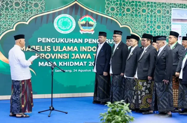 Suasana khidmat prosesi pembacaan naskah pengukuhan Pengurus MUI Jateng 2026-2031 oleh Ketua Umum MUI Pusat di Gradhika Bhakti Praja, Semarang. Tampak jajaran pengurus baru dari unsur ulama dan akademisi berdiri berbaris mengenakan jas hitam, peci, dan kain sarung.