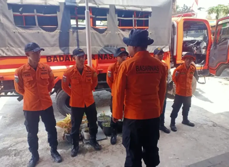 Anggota Tim SAR Semarang berseragam oranye sedang melakukan apel koordinasi di depan truk Basarnas untuk persiapan operasi evakuasi pendaki jatuh di kawah Gunung Slamet.