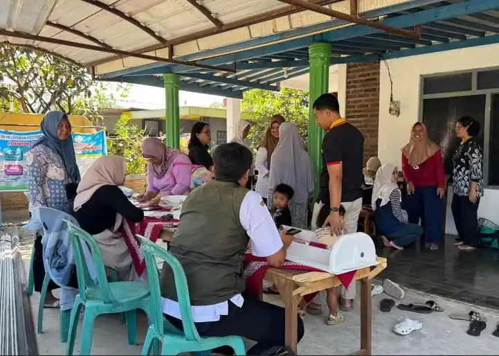 Kader kesehatan dan warga berinteraksi secara hangat dalam pelayanan kesehatan anak di Posyandu Dusun Daleman Tuntang guna memantau gizi balita.