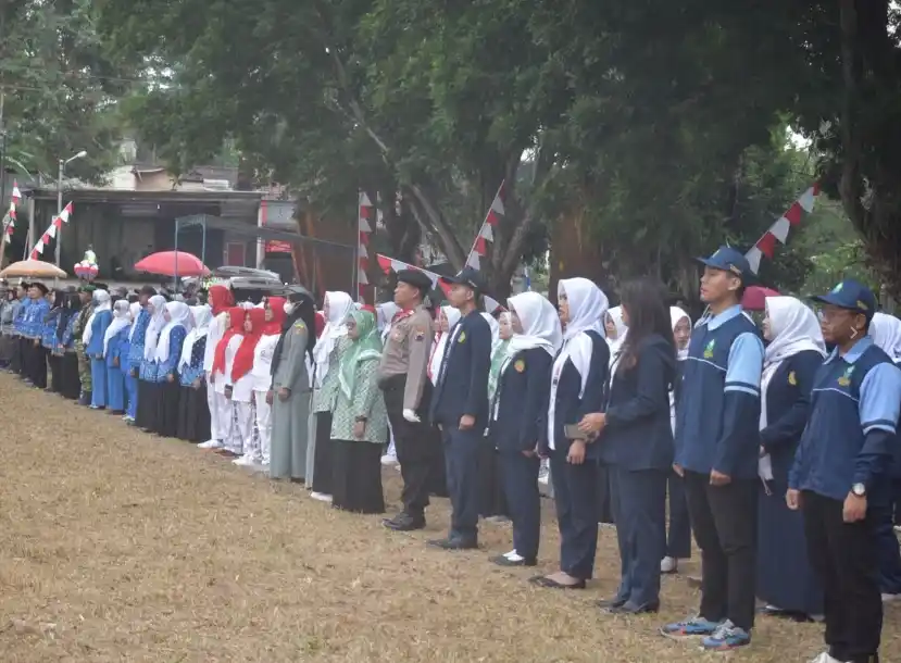 Mahasiswa KKN UIN Walisongo Semarang mengenakan jas almamater berdampingan dengan aparat dan warga saat mengikuti upacara HUT ke-81 RI di Lapangan Tlogo Kecamatan Tuntang sebagai wujud nasionalisme pemuda desa.