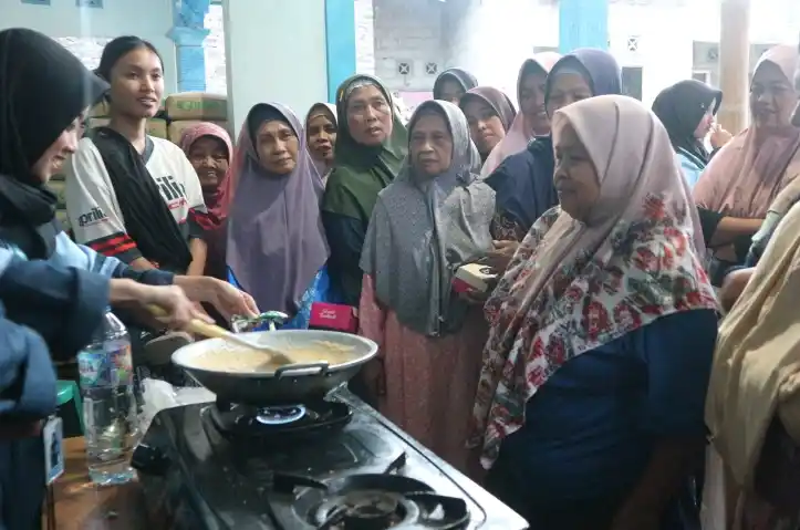 Mahasiswa KKN UIN Walisongo mempraktikkan cara membuat bubur singkong di wajan bersama warga Dusun Sobowono Magelang.