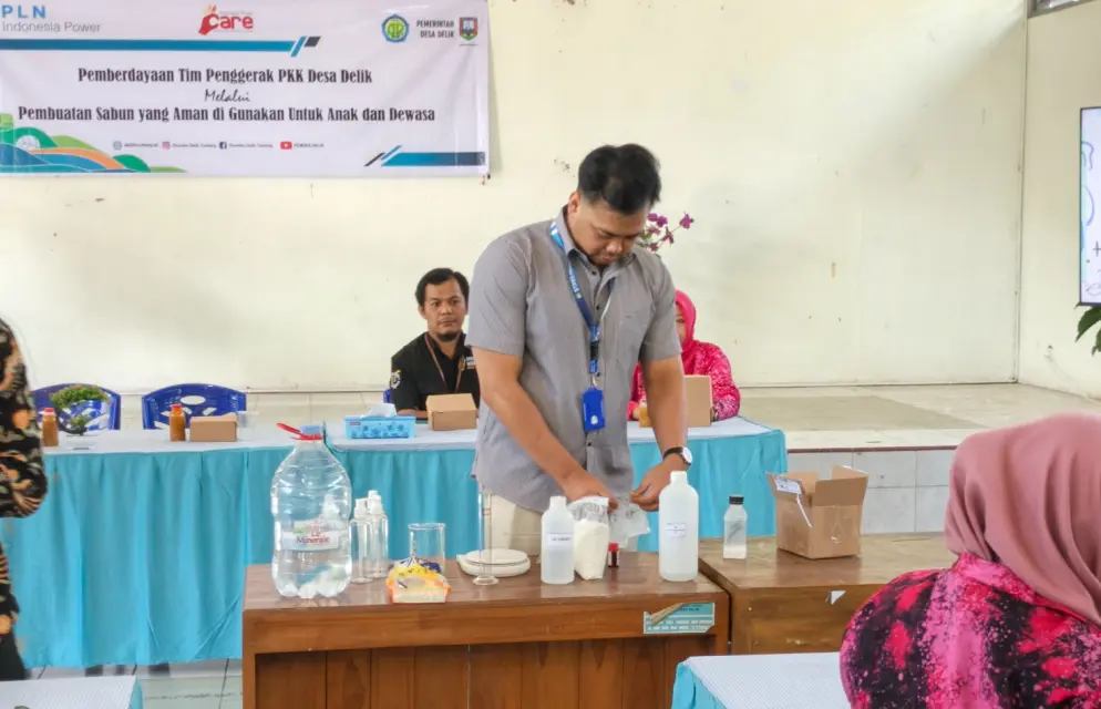 Instruktur farmasi sedang meracik bahan pembuatan sabun cair di atas meja dalam kegiatan pemberdayaan masyarakat desa untuk ibu-ibu PKK di Balai Desa Delik, Kabupaten Semarang.