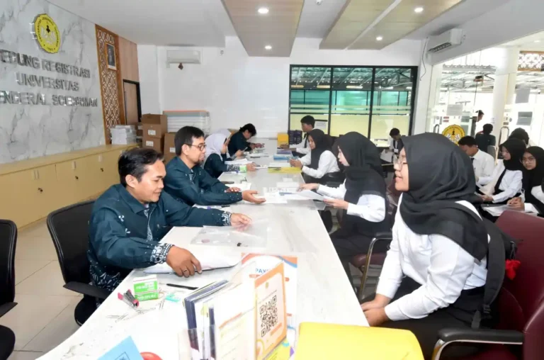 Calon mahasiswa baru mengenakan kemeja putih sedang duduk mengikuti proses verifikasi berkas fisik dalam rangkaian registrasi Jalur Mandiri Unsoed bersama petugas akademik di Gedung Registrasi Universitas Jenderal Soedirman.