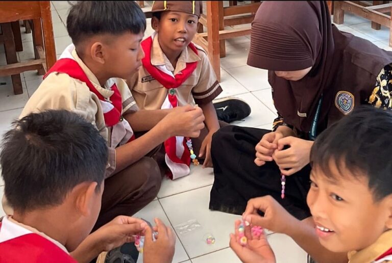 Sekelompok siswa berseragam pramuka di SD N Mranak 1 Demak fokus merangkai kerajinan manik-manik didampingi mahasiswa KKN UIN Walisongo.