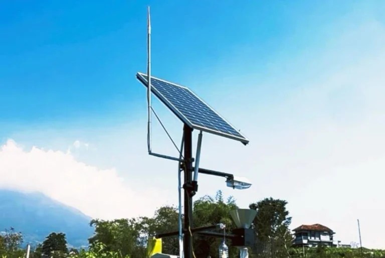 Alat Smart Light Trap bertenaga surya dengan panel surya dan sensor penangkap hama berdiri di lahan pertanian berlatar pegunungan di Desa Campuranom, Temanggung.