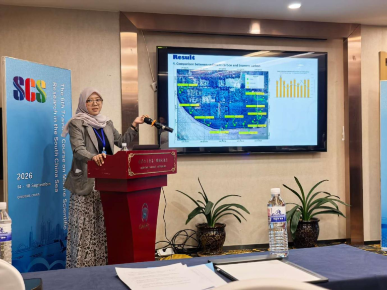 Delegasi Peneliti Unsoed yang mengenakan jas abu-abu dan hijab sedang mempresentasikan hasil riset di podium pada acara 6th Training Course on Marine Scientific Research in the South China Sea di Qingdao, China.