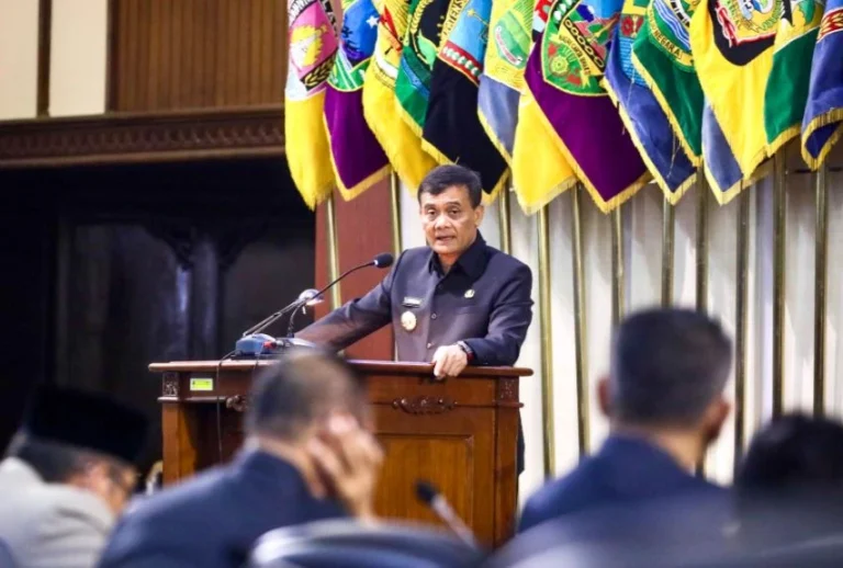 Gubernur Jawa Tengah Ahmad Luthfi berpidato di podium saat Rapat Paripurna DPRD membahas perubahan APBD Jateng 2026 dengan latar belakang deretan bendera lambang daerah.