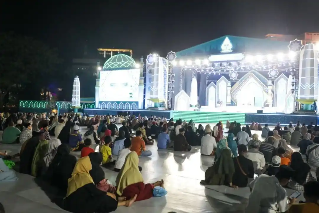 Potret antusiasme warga Semarang yang duduk lesehan di atas hamparan terpal saat menyaksikan langsung panggung utama MTQ Nasional di Lapangan Simpang Lima pada malam hari.