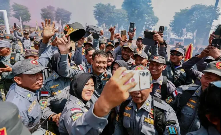 Kerumunan anggota Satlinmas Jateng berseragam abu-abu tampak ceria berswafoto menggunakan telepon seluler di lapangan terbuka.