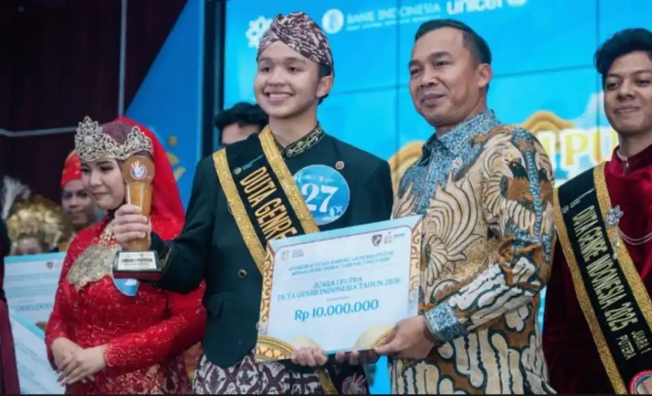 Arya Fatikh Izzan Juweri, mahasiswa Undip memakai selempang Duta GenRe, memegang piala dan plakat Juara 1 Putra Duta GenRe Indonesia 2026 senilai Rp 10.000.000 bersama pejabat terkait di panggung.