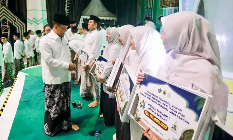 Gubernur Jawa Tengah menyerahkan hadiah juara MTQ nasional berupa simbolis tiket umrah dan uang pembinaan kepada para kafilah berprestasi di atas panggung.