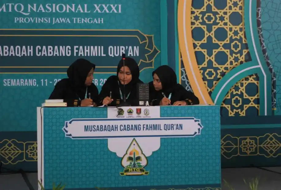 Tiga srikandi Regu A Kafilah Aceh Juara Fahmil Quran putri sedang berdiskusi di atas panggung babak final MTQ Nasional 2026 di Semarang.