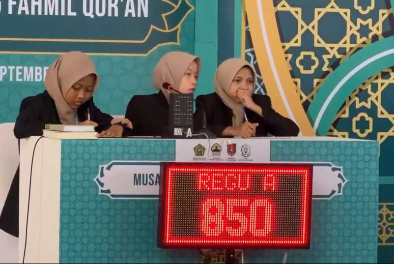 Tiga peserta Regu A Fahmil Quran Puteri Jateng tampak tegang dan berkonsentrasi penuh menatap dewan hakim di belakang papan skor digital bertuliskan angka 850 pada sesi cerdas cermat MTQ Nasional 2026 di UIN Walisongo Semarang.