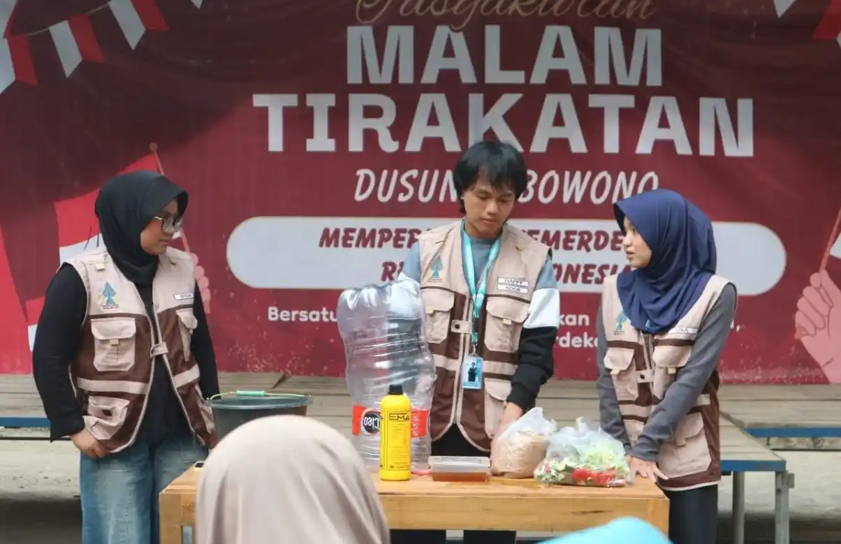 Tiga mahasiswa KKN MMK UIN Walisongo mendemonstrasikan tahapan pembuatan komposter galon bertingkat menggunakan wadah bekas dan bahan organik.