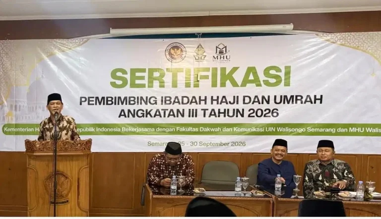Suasana penyampaian sambutan di podium berlatar spanduk Sertifikasi Pembimbing Ibadah Haji dan Umrah Angkatan III Tahun 2026 oleh FDK UIN Walisongo Semarang.